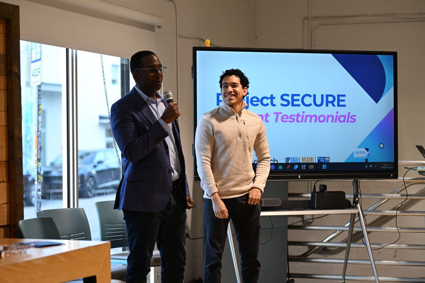 A Project SECURE student smiling while presenting at a student testimonials event